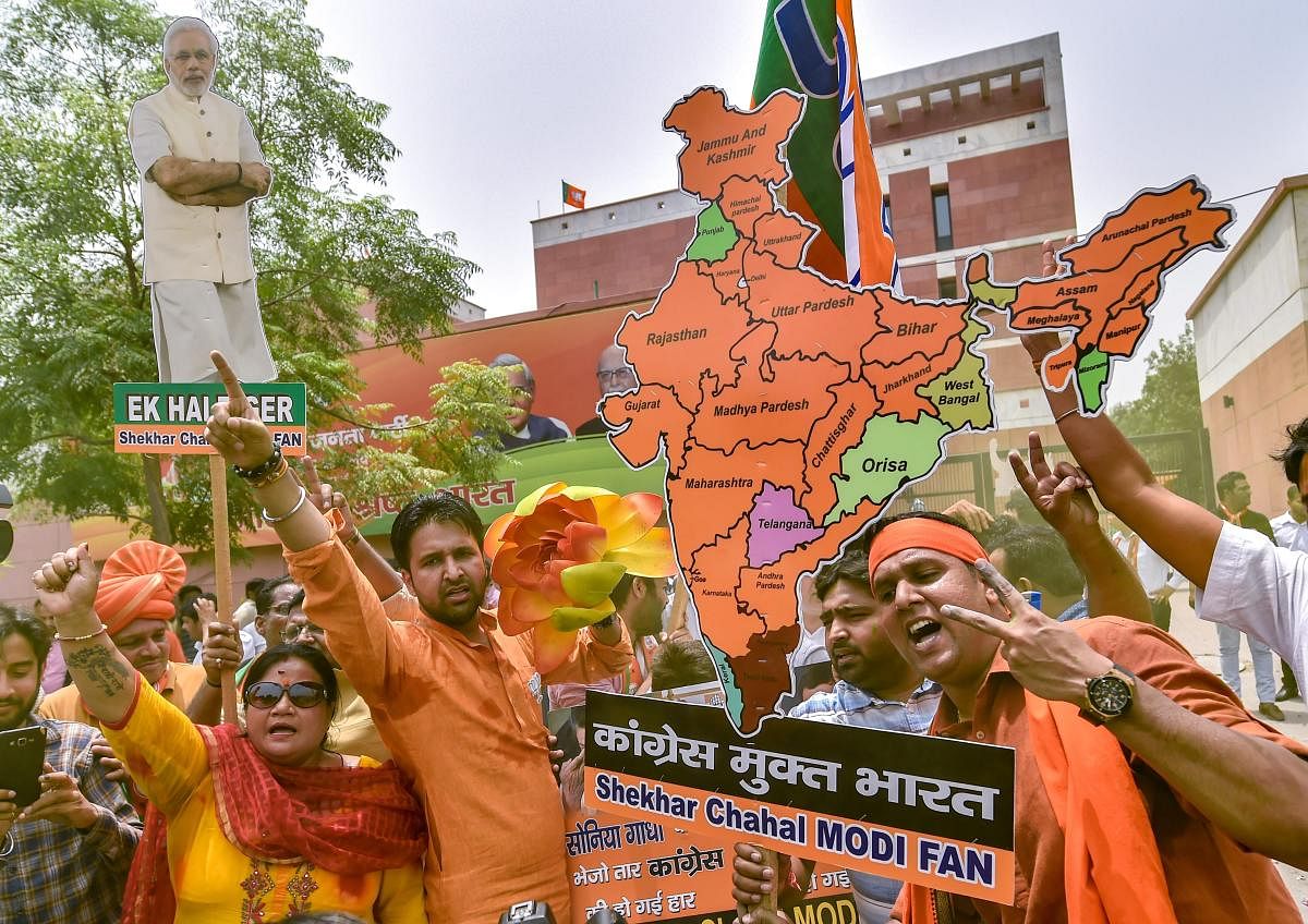 BJP workers celebrate the party's lead during the counting of votes for Karnataka Assembly elections, at the party headquarters in New Delhi, on Tuesday.