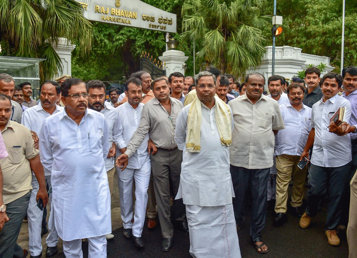 Outgoing Karnataka Chief Minister Siddaramaiah, JD(S) President H D Kumaraswamy with other leaders leave after meeting with Governor Rudabhai Vajubhai Vala as Congress extends party support to JD(S) to form the new government after Karnataka Assembly Election results 2018 in Bengaluru on Tuesday. PTI Photo