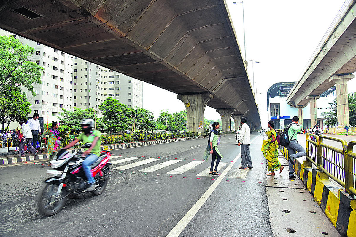 Pedestrians struggle to cross the road, at Nagasandra Metro Station, in Bengaluru on Thursday. DH Photo/ B H Shivakumar