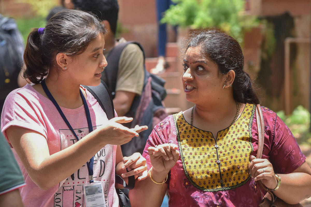 A student seen discussing the exam paper with her mother at the Dayananda Sagar College on Sunday. DH Photo/S K Dinesh