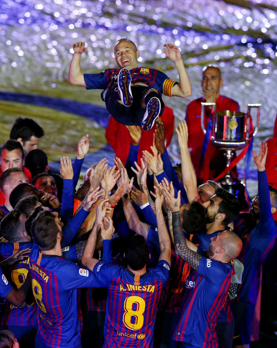  Andres Iniesta is tossed up in the air by Barcelona players after the midfielder's final game for the club on Sunday. REUTERS 