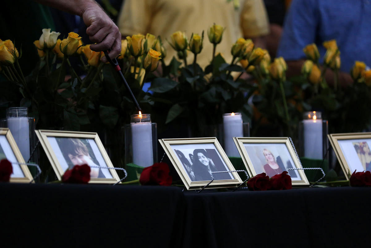 Candles are lit behind images of the victims killed in a shooting at Santa Fe High School during a vigil in League City, Texas, U.S., May 20, 2018. (REUTERS)