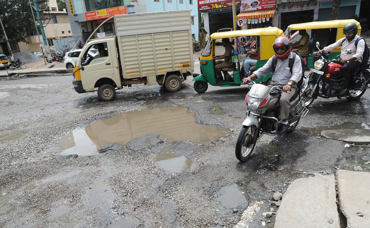 Huge potholes on the 89 Feet Road of Hosakerehalli Cross at Banashankari on Monday. DH Photo/Srikanta Sharma R.