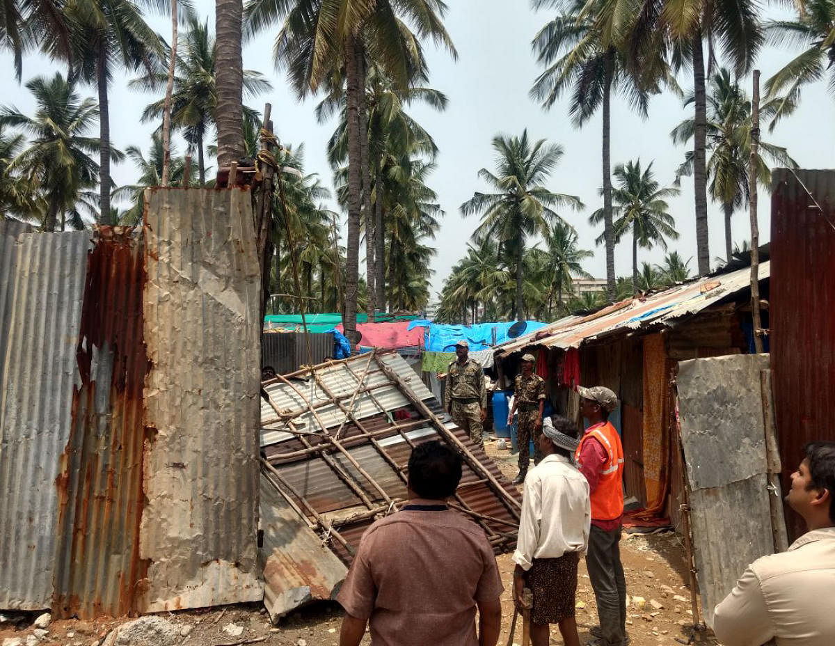 BBMP workers remove the illegal shanties from the buffer zone of Bellandur Lake on Tuesday.