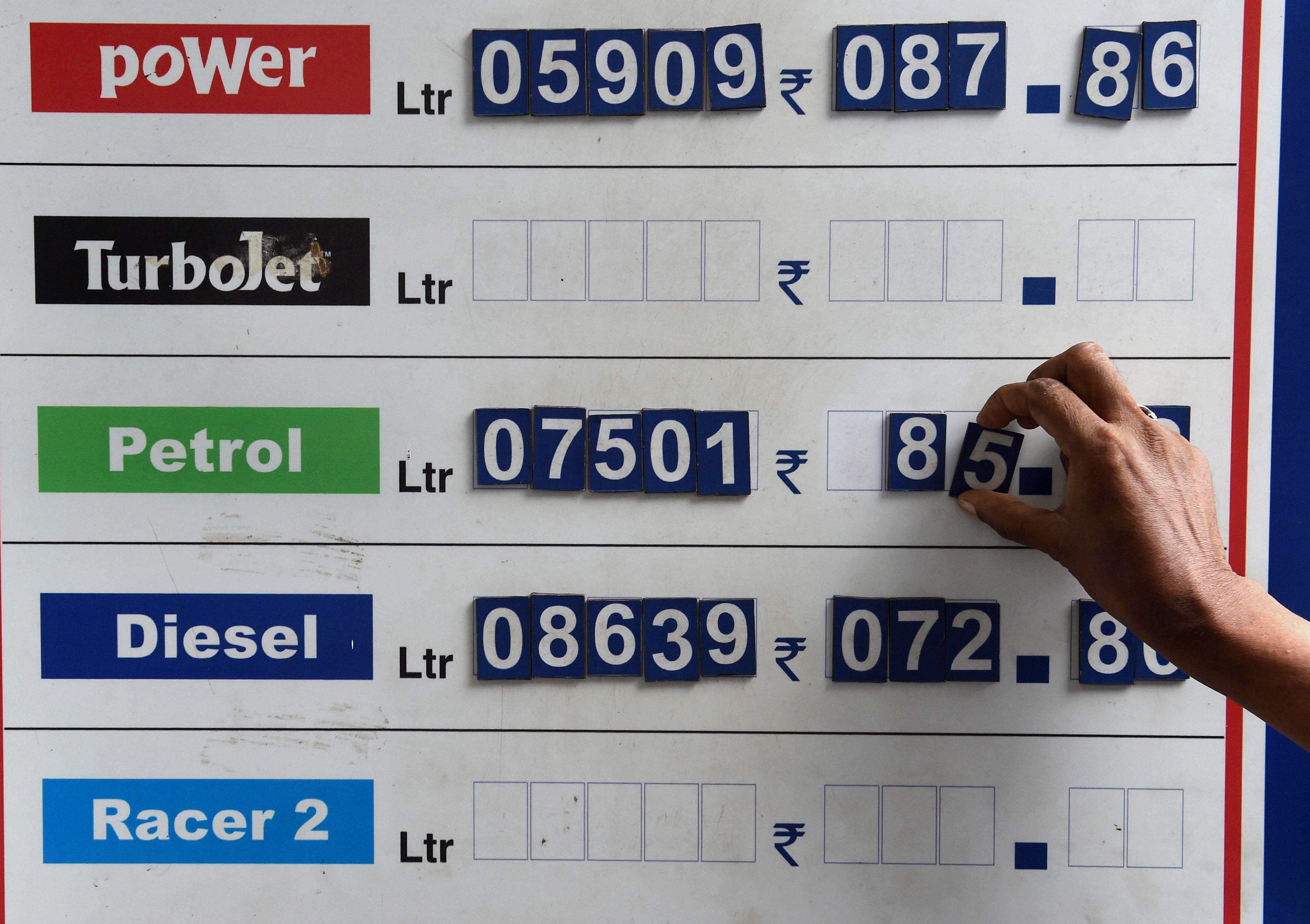 A petrol pump employee adjusts the fuel rate card as the price reaches highest-ever, in Mumbai, on Wednesday. PTI