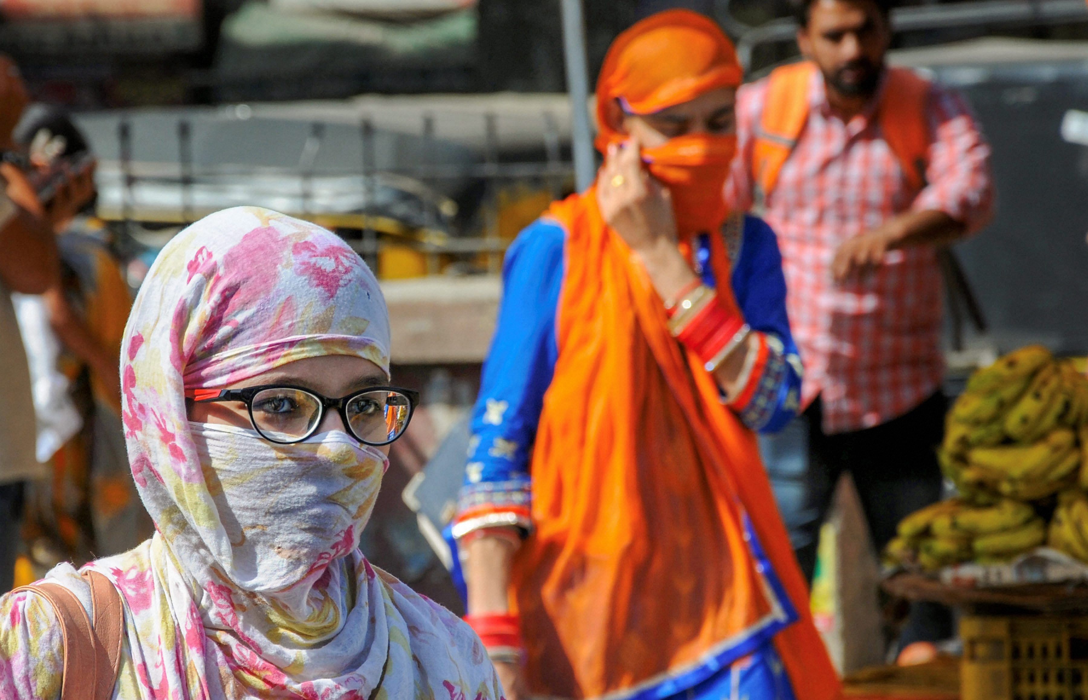 People shield themselves against direct heat on a hot, summer day, as temperature soars, in Amritsar, on Wednesday. PTI