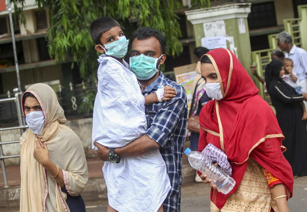 People wear safety masks as a precautionary measure after the 'Nipah' virus outbreak, at Kozhikode Medical College, in Kerala, on Friday. PTI Photo