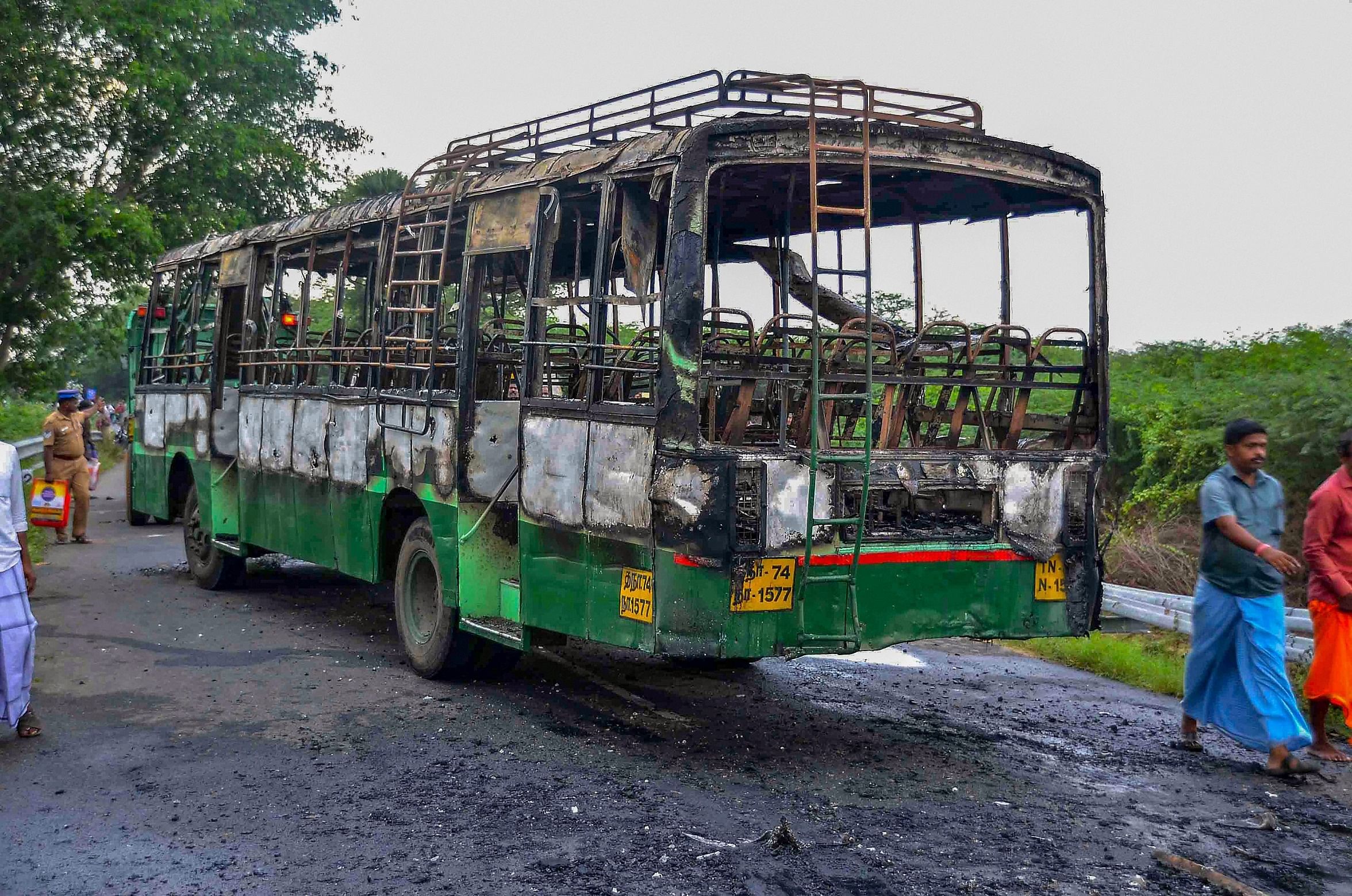 A man walks past a vandalised government bus during a violent protest against the closure of Vedanta's Sterlite Copper unit, in Tuticorin, on Friday. PTI 