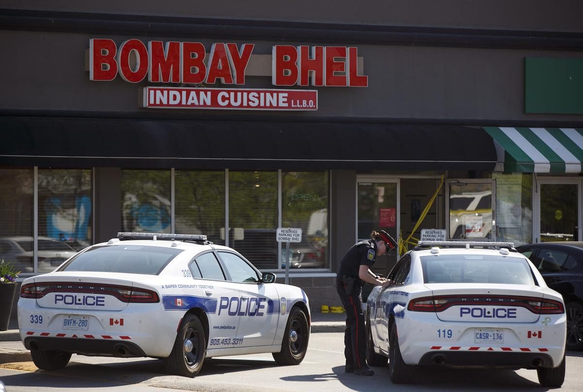 Police stand watch at the scene of an explosion at a restaurant in Mississauga, Ontario, on Friday, May 25, 2018. An explosion caused by a homemade bomb ripped through an Indian restaurant where children were present for family parties at a mall in the To