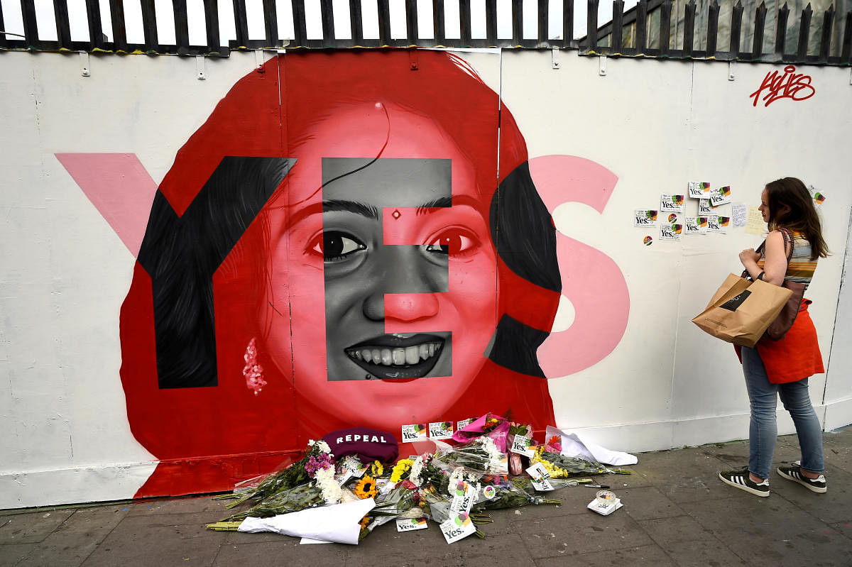 A woman looks at a new mural of Savita Halappanavar with flowers placed beneath it put up on the day of the Abortion Referendum on liberalising abortion laws in Dublin, Ireland May 25, 2018. REUTERS File photo