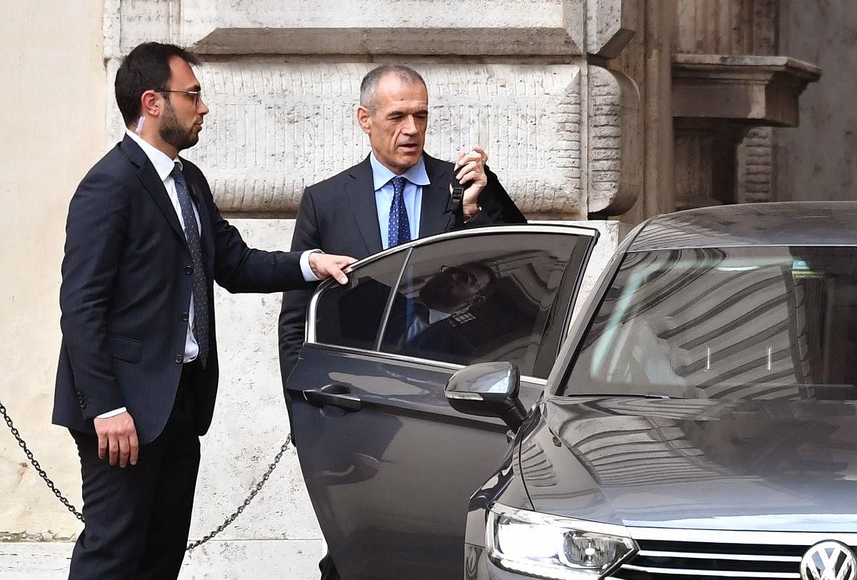 Caretaker prime minister Carlo Cottarelli (right) leaves the Italian Parliament for an informal meeting with the president in Rome on May 30, 2018. AFP