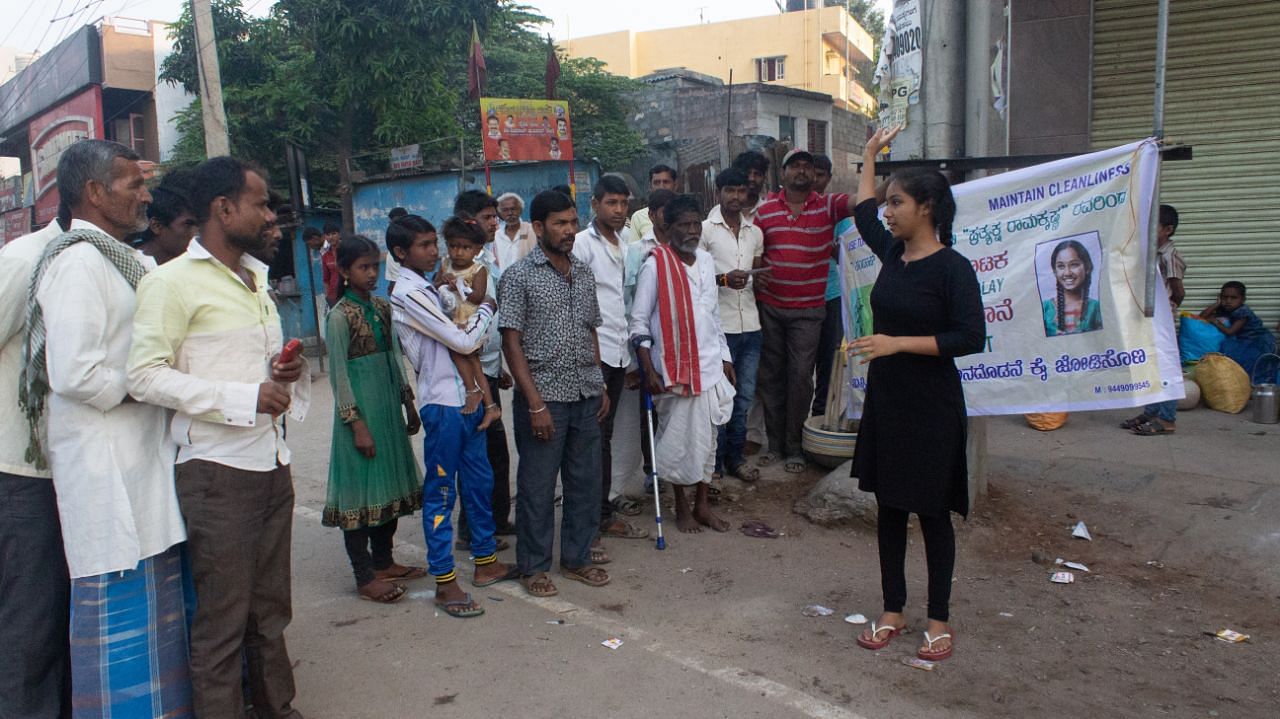 Prathyaksha performing a street play in front of villagers.