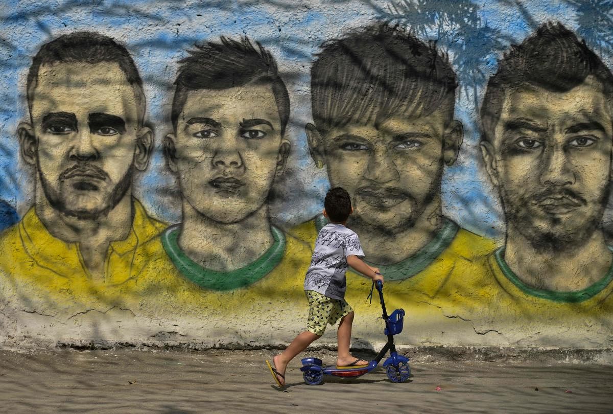 HEROES: A boy looks at a graffiti showing World Cup football players in Camboata neighbourhood of Rio de Janeiro. AFP