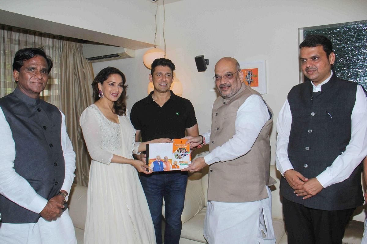 BJP president Amit Shah along with Maharashtra Chief Minister Devendra Fadnavis meets Bollywood actress Madhuri Dixit at her Juhu residence as a part of his 'Sampark Se Samarthan' campaign, in Mumbai on Wednesday. PTI