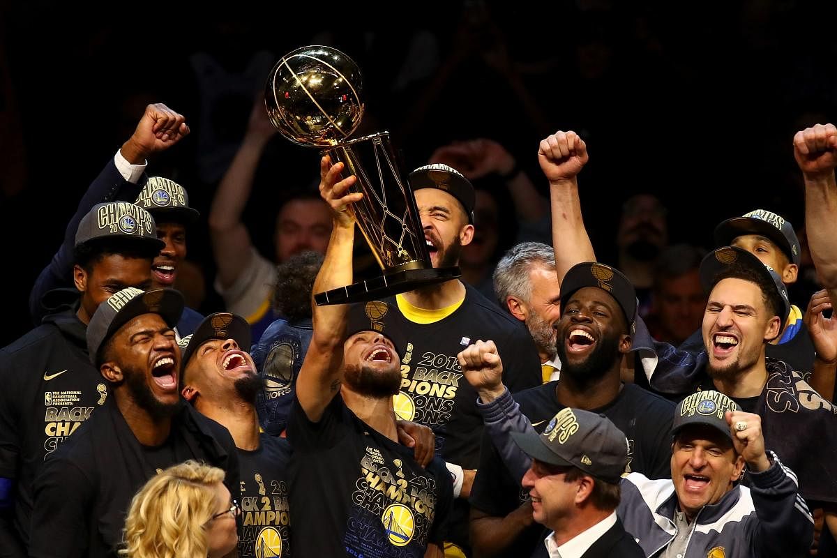 Golden State Warriors celebrate with the Larry O'Brien Trophy after defeating the Cleveland Cavaliers in Game Four of the 2018 NBA Finals on Friday. AFP