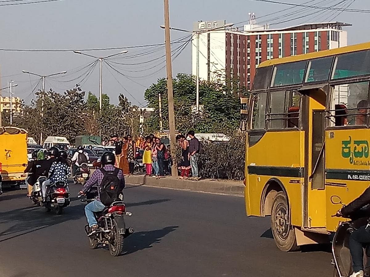 College students struggling to cross the busy ORR near Kadabeesanhalli, opposite New Horizon Engineering College.