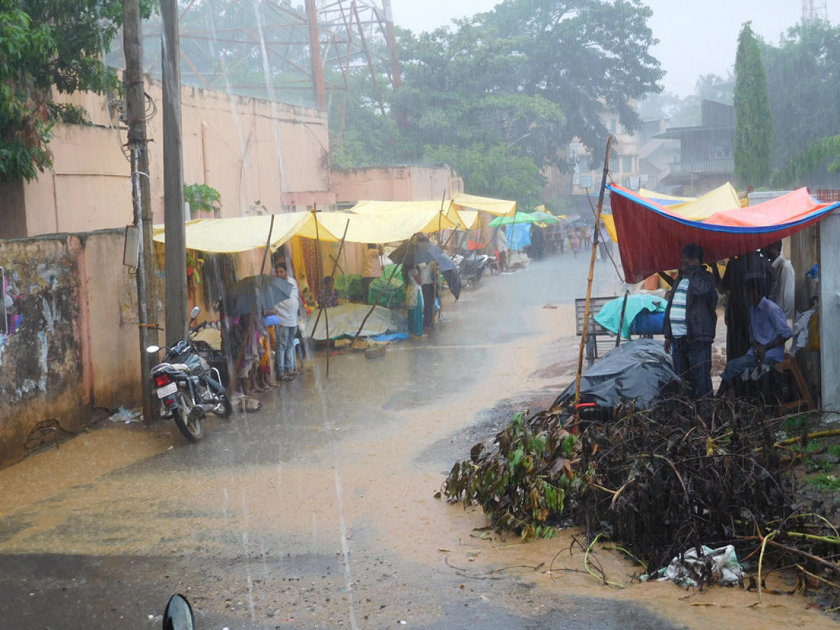 Vendors wait for customers on a rainy day at Haliyal in Uttara Kannada district. dh photo