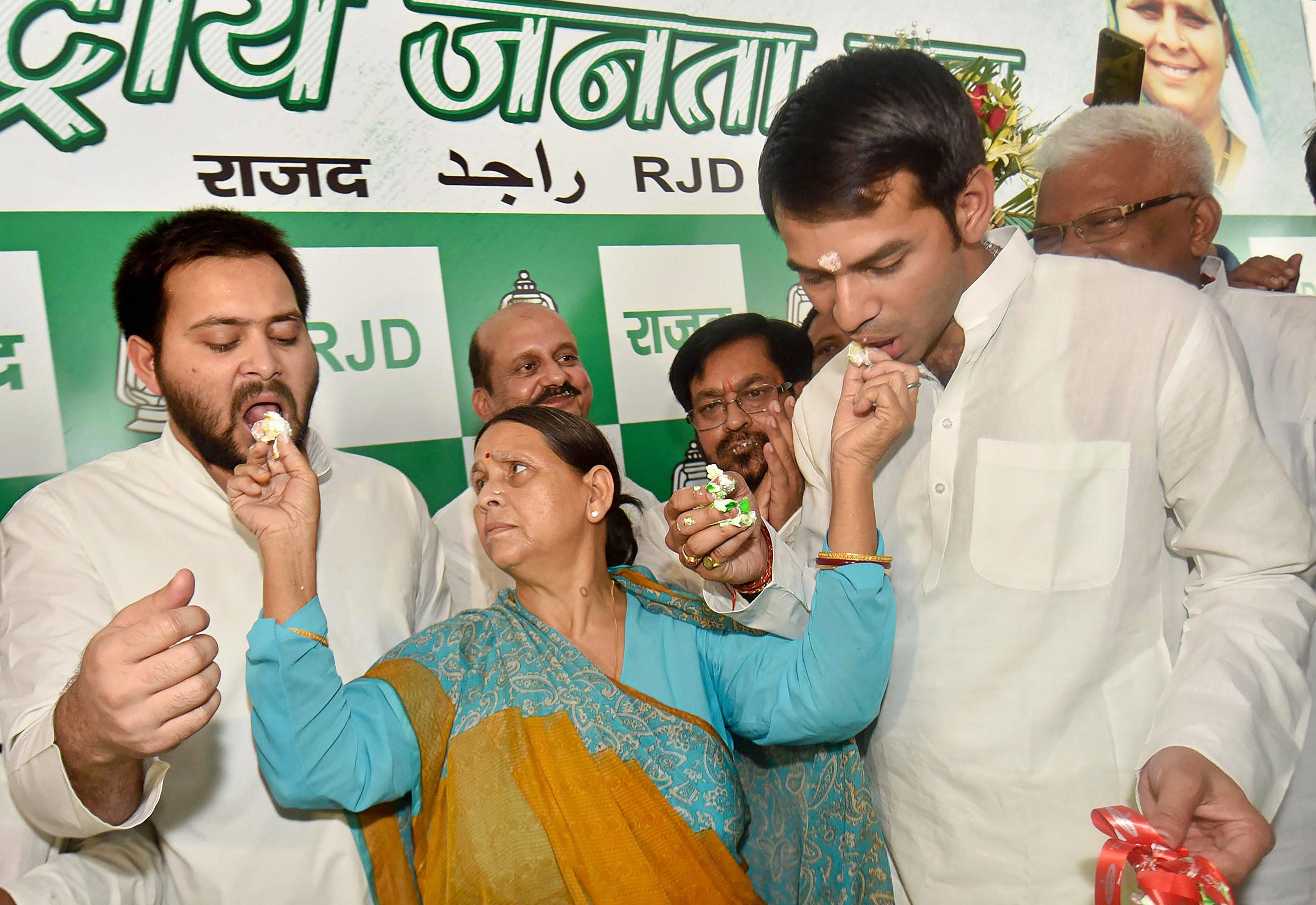 Former CM Rabri Devi shares cake with her sons Tejaswi and Tej Partap while celebrating her husband RJD chief Lalu Prasad's 71st birthday in Patna on Monday. PTI