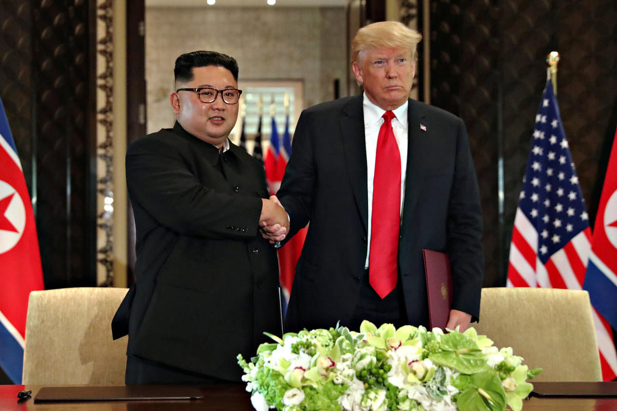 U S President Donald Trump shakes hands with North Korea's leader Kim Jong Un after they signed documents that acknowledged the progress of the talks and pledge to keep momentum going, after their summit at the Capella Hotel on Sentosa island in Singapore