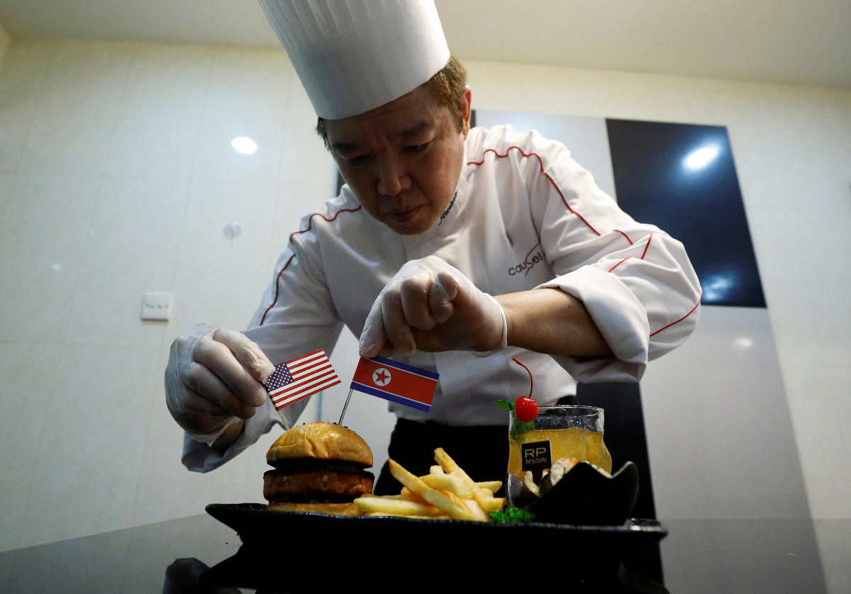 Chef Abraham Tan of Royal Plaza on Scotts' Carousel restaurant puts finishing touches to his creation, the Trump Kim burger, in Singapore. Reuters photo.