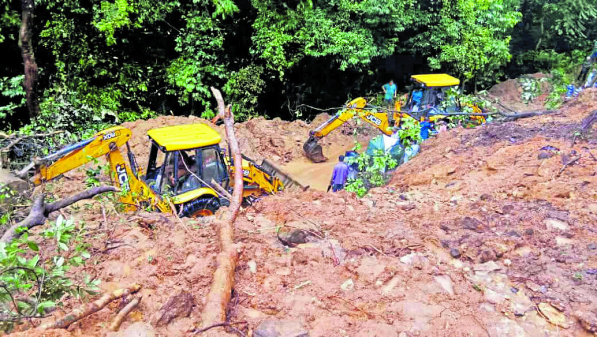 Excavators clear a section of the Charmadi Ghat which was blocked due to landslides on Tuesday.
