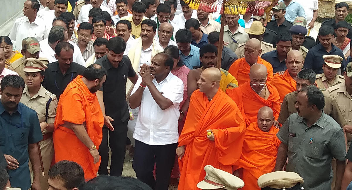 Chief Minister H D Kumaraswamy greets his supporters after participating in a special puja at Adichunchanagiri Mutt in Nagamangala taluk, Mandya district, on Wednesday. Seer Nirmalanandanatha Swami is seen. DH Photo