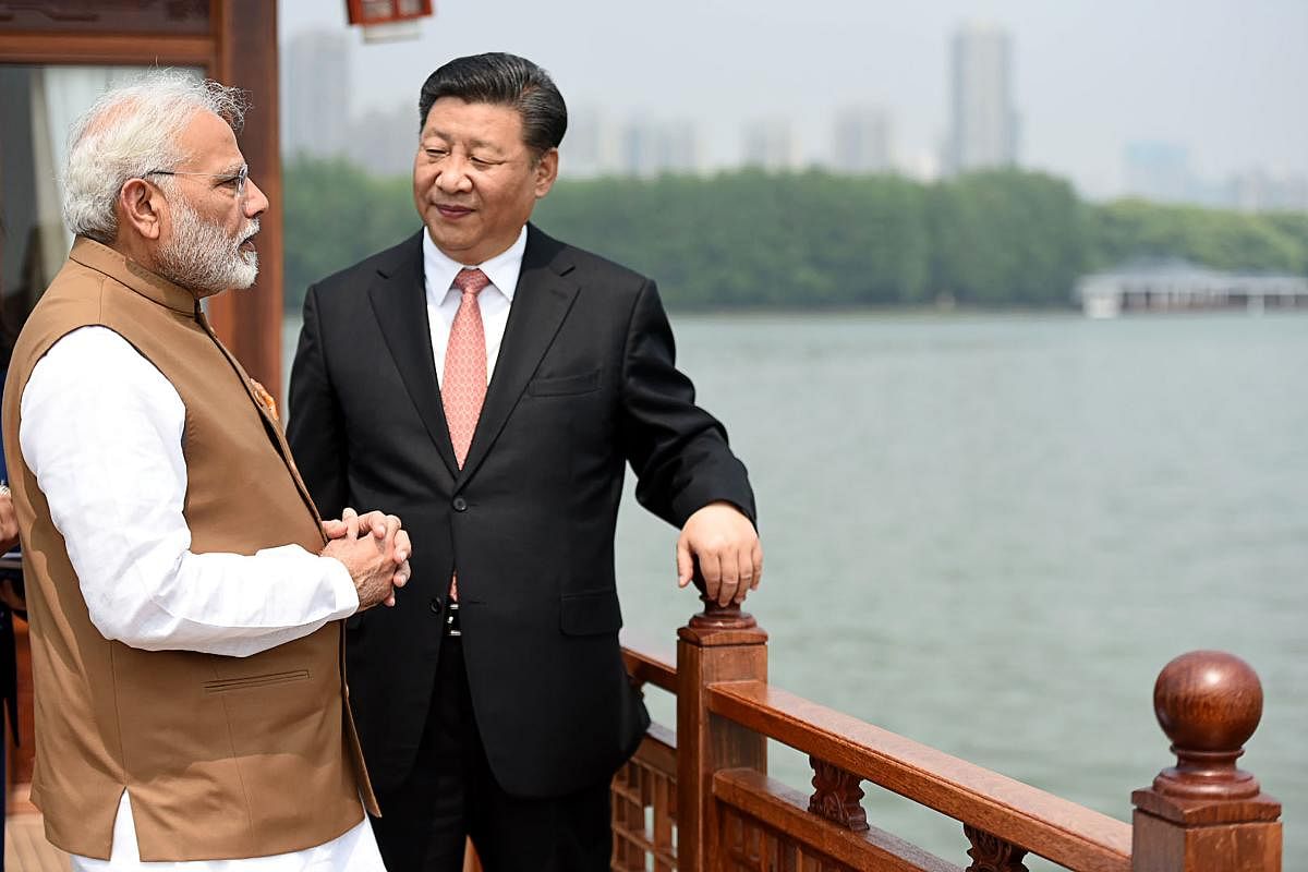 This handout photograph released by India's Press Information Bureau (PIB) on April 28, 2018 shows India's Prime Minister Narendra Modi (L) and Chinese President Xi Jinping looking on in a house boat, at East Lake, in Wuhan. Chinese President Xi Jinping a