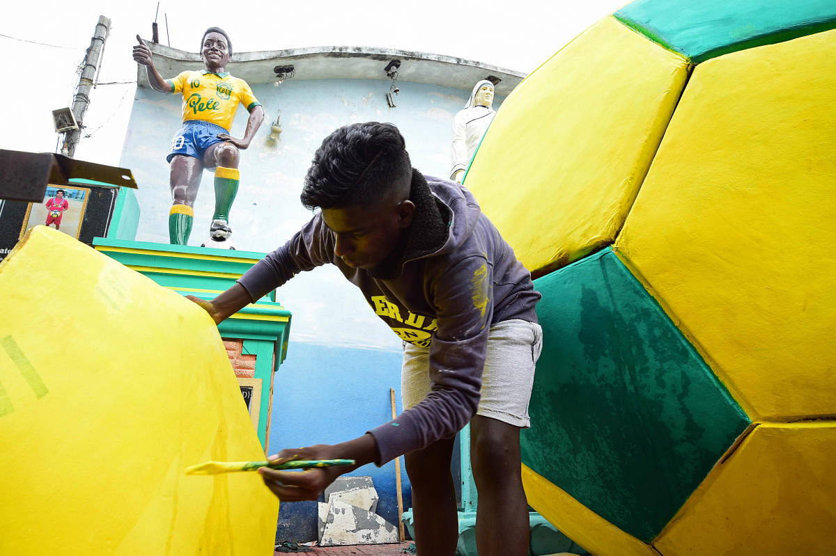 A football fan in Gowthampura gives finishing touches to the settings in the neighbourhood ahead of the World Cup on Wednesday. DH Photo