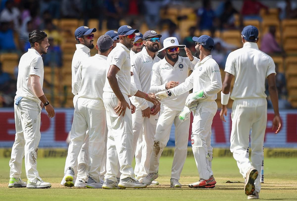 Umesh Yadav with teammates celebrates the wicket of Afghanistan batsman Mohammad Nabi during the second day of a one-off test match, at M Chinnaswamy Stadium, in Bengaluru on Friday, June 15, 2018. PTI Photo