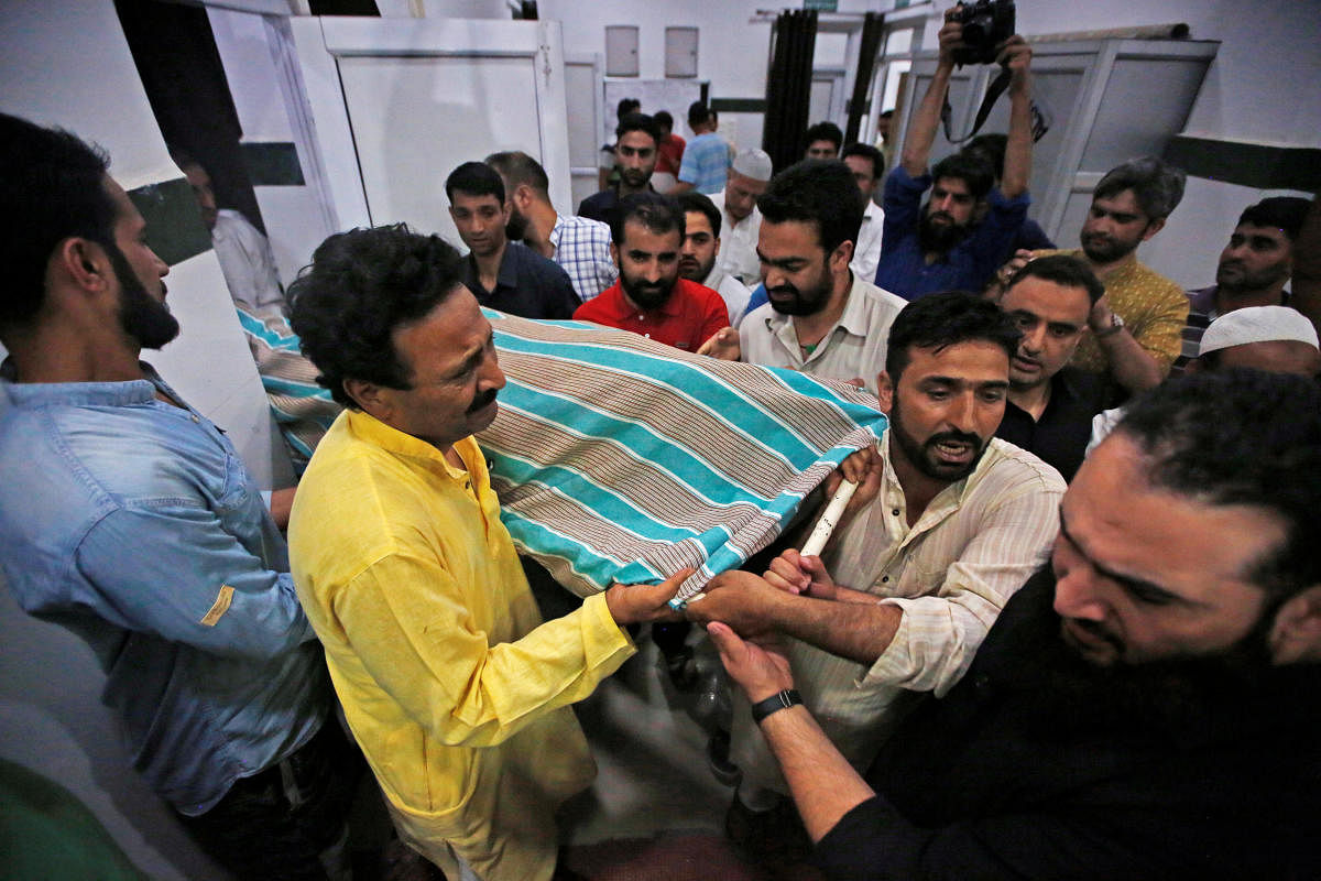People carry the body of Syed Shujaat Bukhari, the editor of Rising Kashmir daily newspaper, who was killed by unidentified gunmen outside his office in Srinagar. Reuters photo.