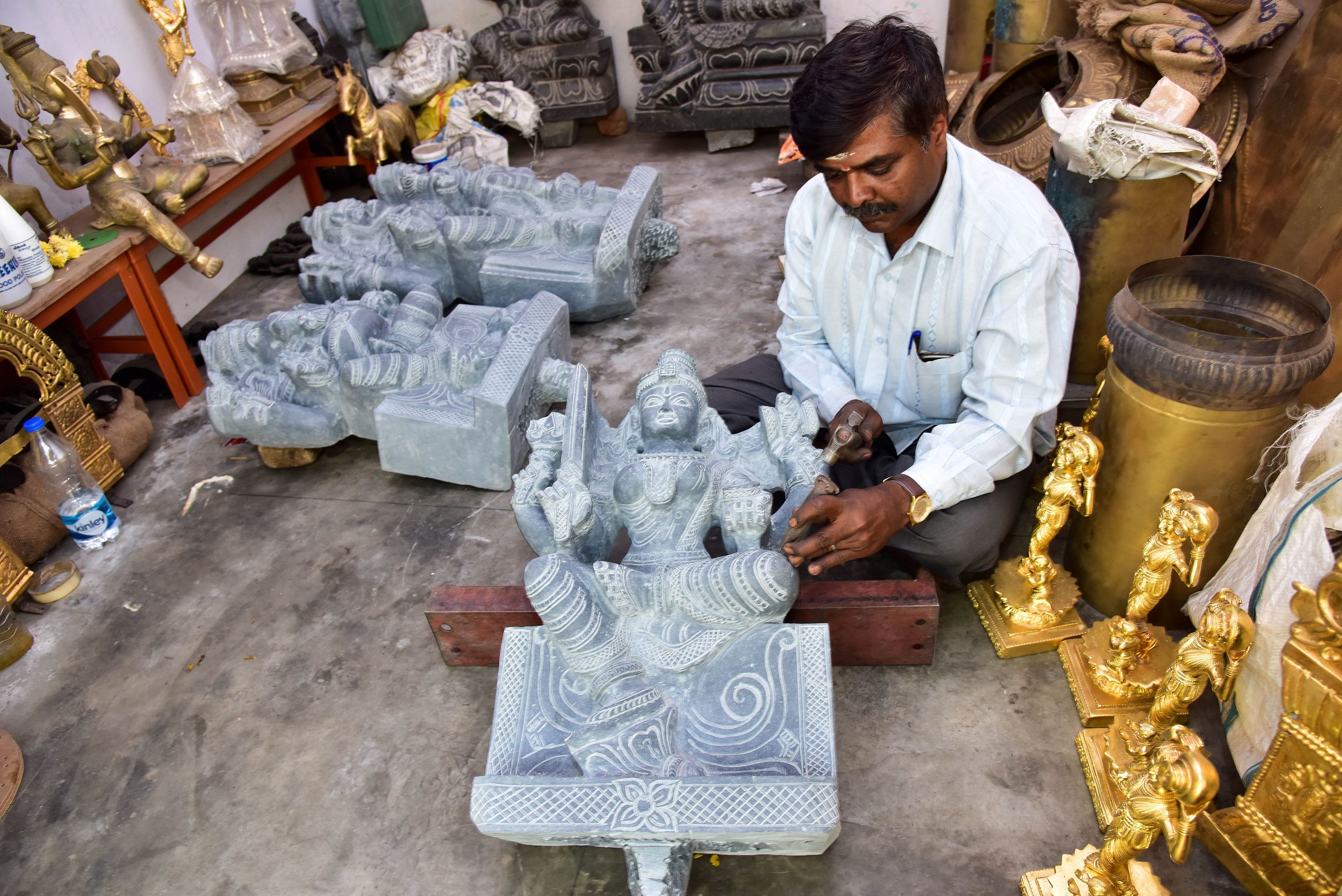 Stone carver Manjunath Achar giving final touches to a statue. DH Photo by B H Shivakumar