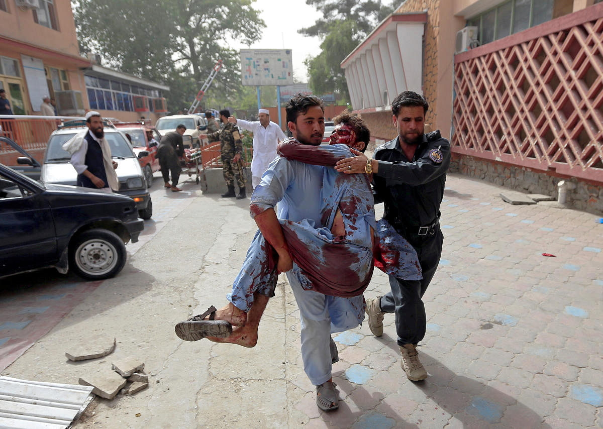 Men carry an injured man to a hospital after a car bomb in Jalalabad city, Afghanistan June 17, 2018. REUTERS