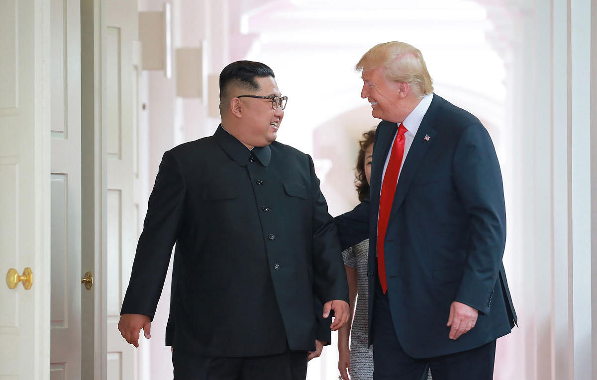 In this picture taken on June 12, 2018 and released from North Korea's official Korean Central News Agency (KCNA) on June 13, 2018, US President Donald Trump (R) and North Korea's leader Kim Jong Un (L) walk to attend their historic US-North Korea summit,