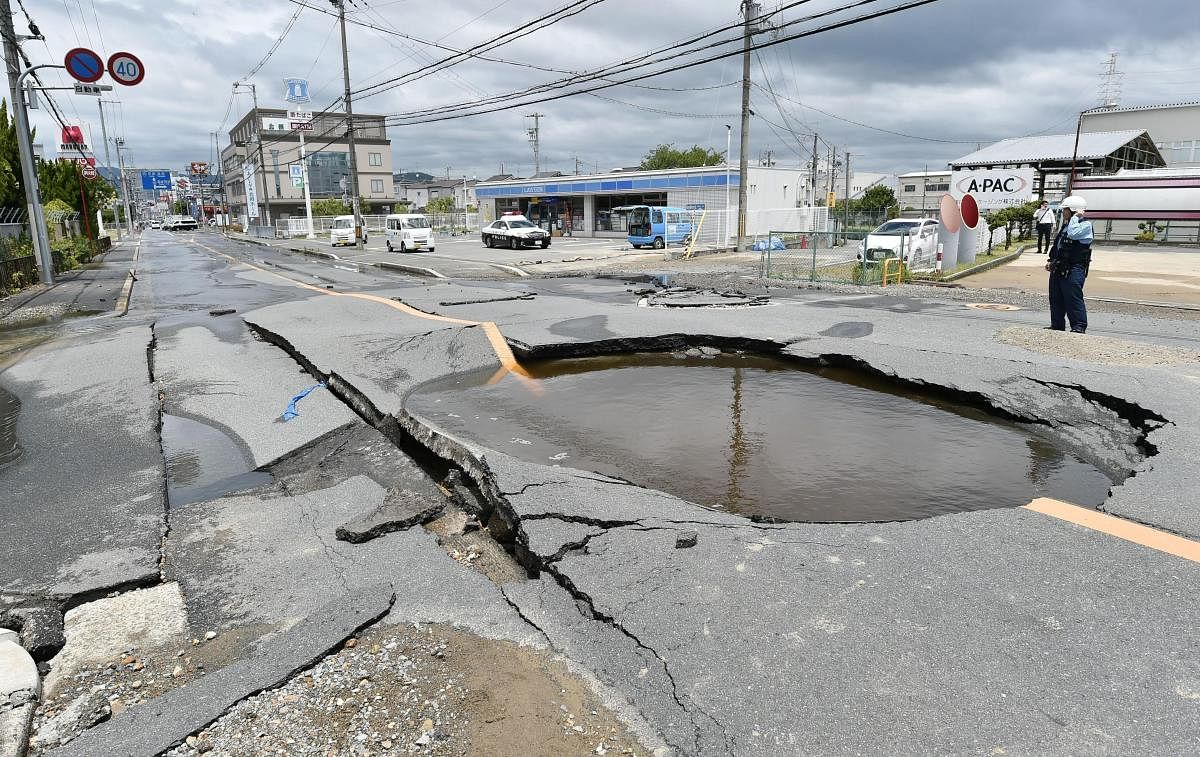 A crack is filled with water on a road after water pipes were broken following an earthquake in Takatsuki city, Osaka, western Japan, Monday. (AP/PTI Photo)