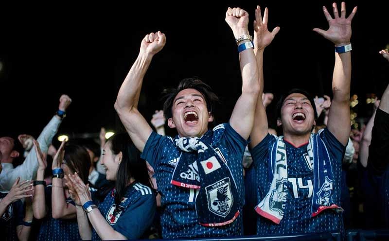 Japanese supporters celebrates Japanese team's goal in the penalty kick while watching Japan's first World Cup match in the Group H against Colombia at a fan zone in Tokyo on June 20, 2018. / AFP PHOTO