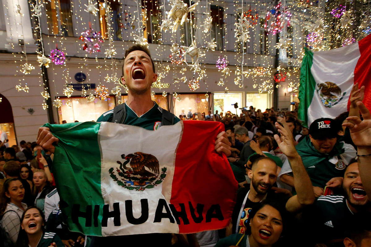 Mexico's fans celebrate victory of their team after the match on Sunday. (REUTERS/Sergei Karpukhin)