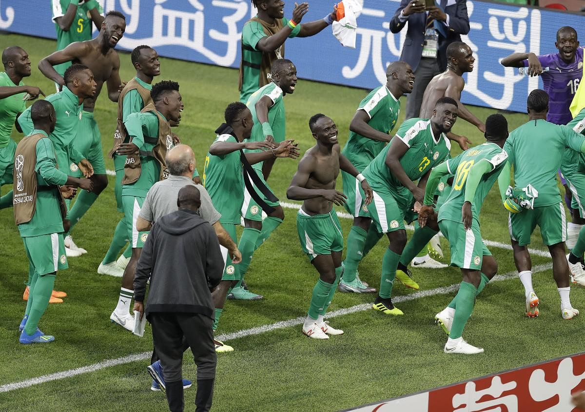 Senegal players celebrate their win over Poland on Tuesday. Senegal became the first African nation to score a win at this World Cup. AP/PTI