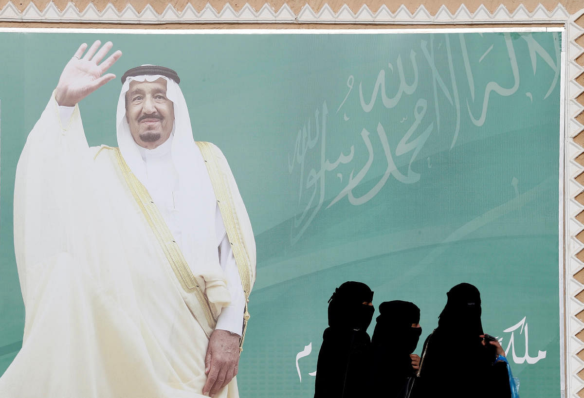 Women walk past a poster of Saudi Arabia's King Salman bin Abdulaziz Al Saud during Janadriyah Cultural Festival on the outskirts of Riyadh, Saudi Arabia. (Reuters file photo)