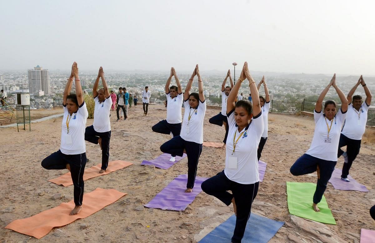 Yoga enthusiasts perform yoga ahead of International Day of Yoga 2018, in Jodhpur on Tuesday. PTI Photo