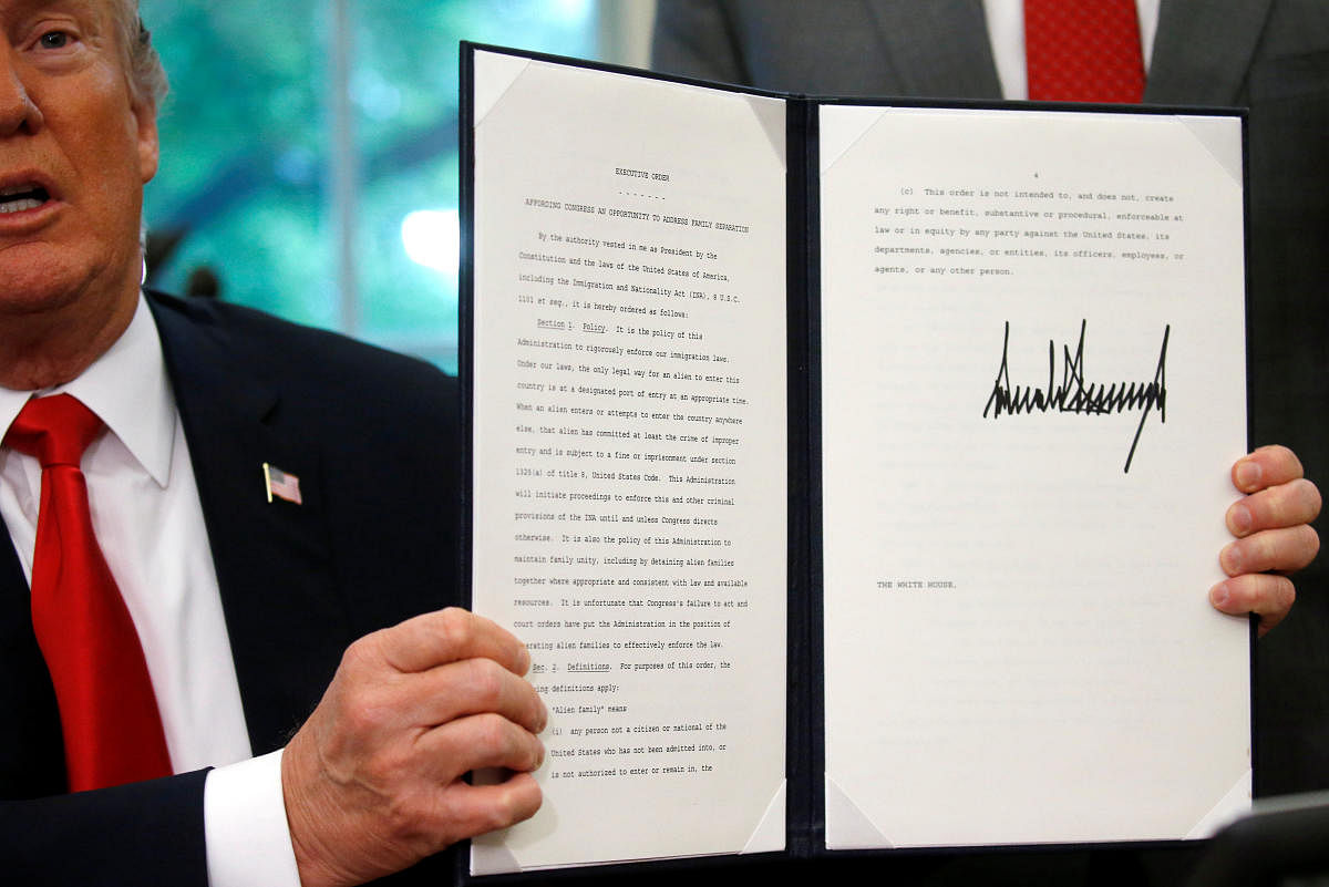 US President Donald Trump displays an executive order on immigration policy after signing it in the Oval Office at the White House in Washington on June 20, 2018. (REUTERS/Leah Millis)