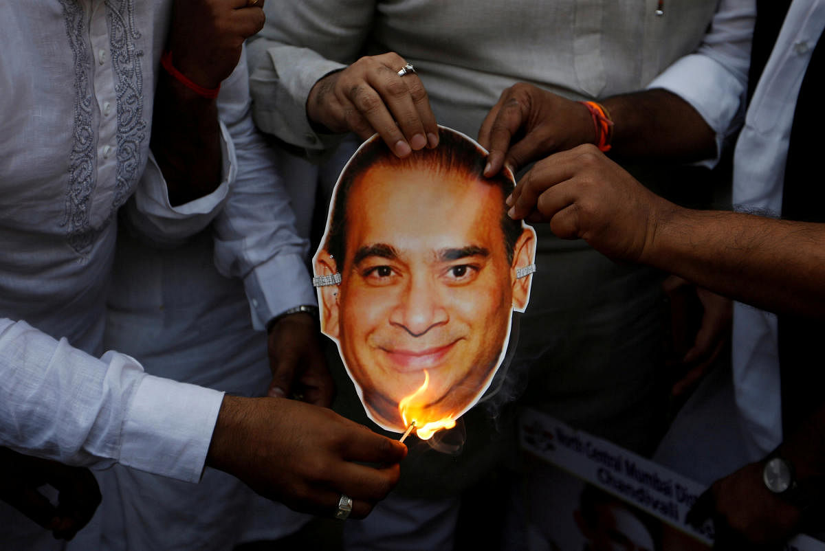 Activists of the youth wing of India's main opposition Congress party burn a cut-out with an image of billionaire jeweller Nirav Modi during a protest in Mumbai, India, February 23, 2018. REUTERS file photo