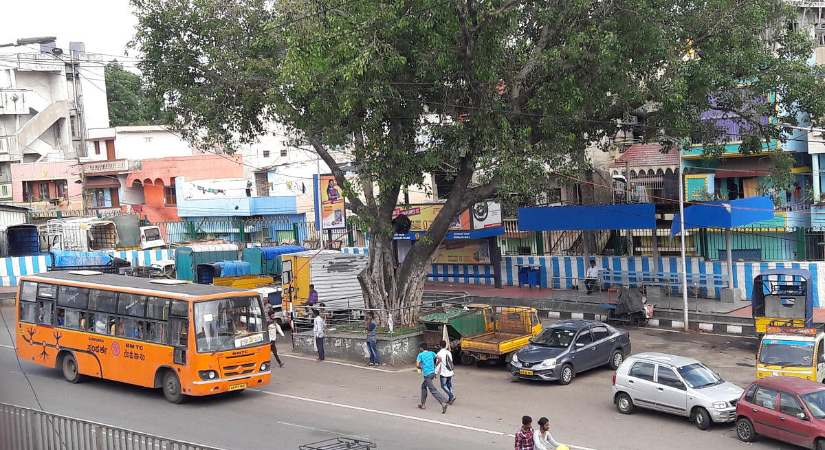 As private vehicles are parked near the bus stop at the Mysuru Road toll gate, BMTC buses are forced to stop along the main road. DH Photo