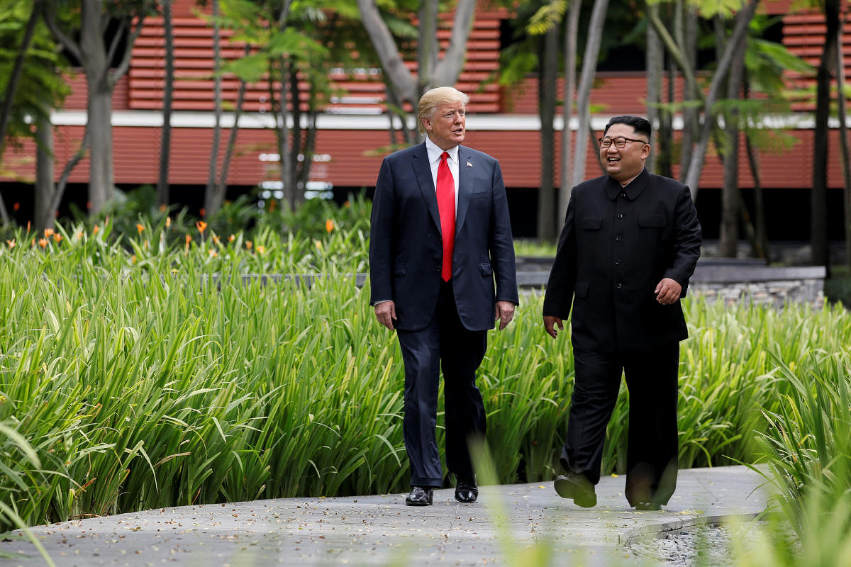 U.S. President Trump and North Korea's Kim walk together before their working lunch during their summit in Singapore. Reuters file photo