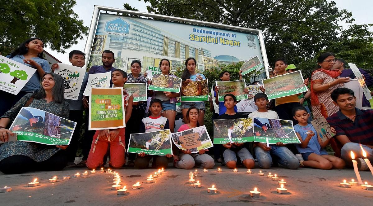  Activists from various environmental organisations during a candle light vigil against cutting of trees in Nauroji Nagar area, in New Delhi. PTI photo.