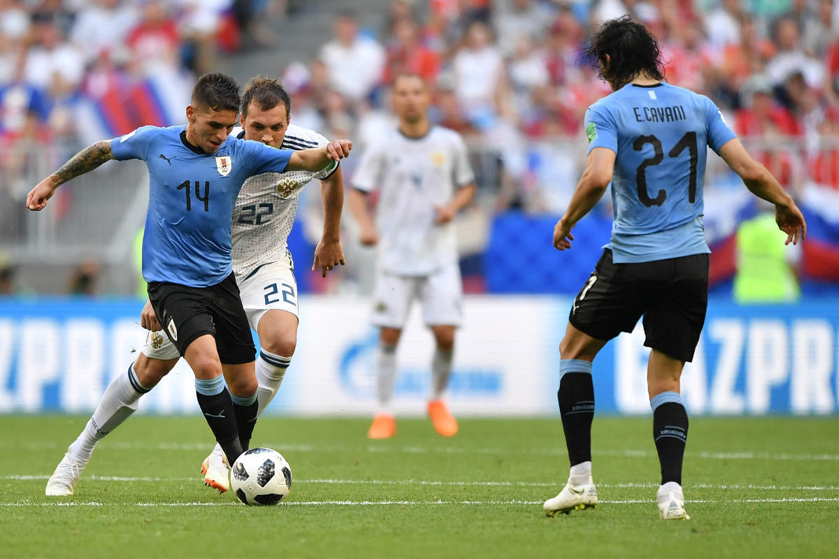 Uruguay's midfielder Lucas Torreira challenges Russia's forward Artem Dzyuba (back L) next to Uruguay's forward Edinson Cavani (R) during the Russia 2018 World Cup Group A football match between Uruguay and Russia at the Samara Arena in Samara on June 25,
