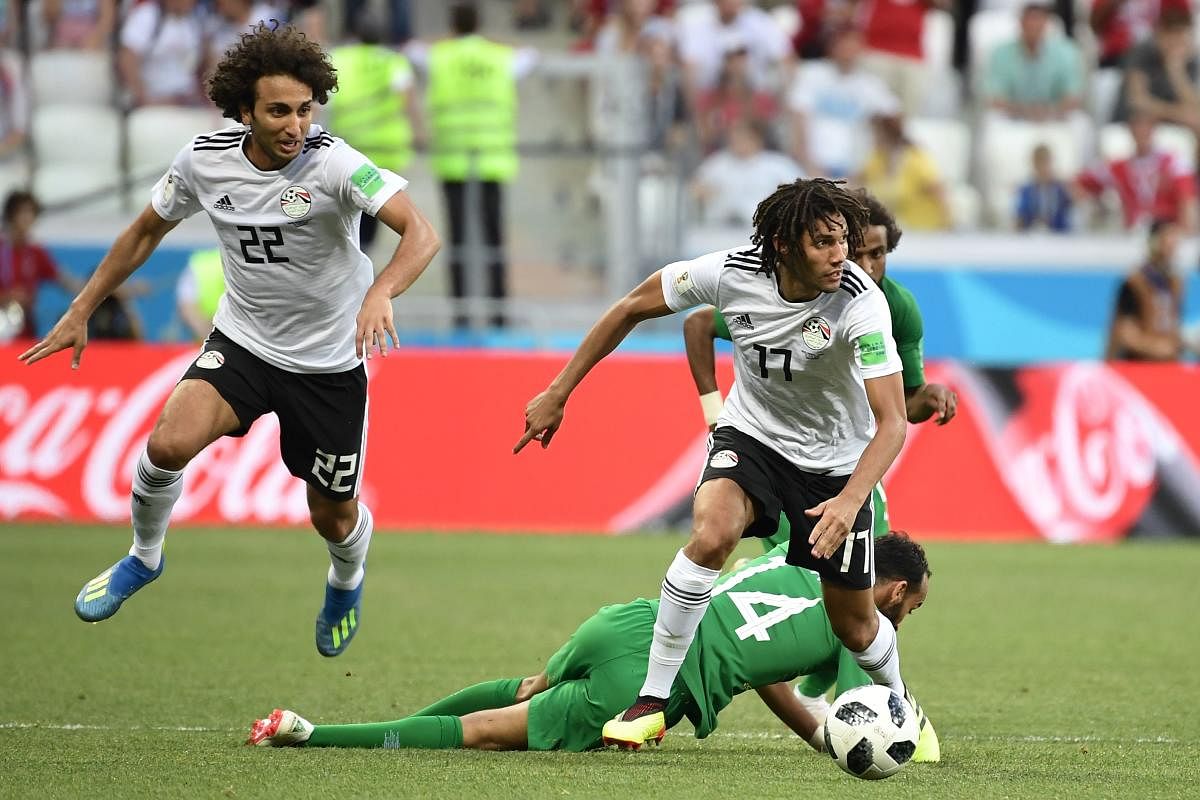 Saudi Arabia's midfielder Abdullah Otayf (bottom) falls while fighting for the ball with Egypt's midfielder Amr Warda (L) and midfielder Mohamed Elneny during the Russia 2018 World Cup Group A football match between Saudi Arabia and Egypt at the Volgograd