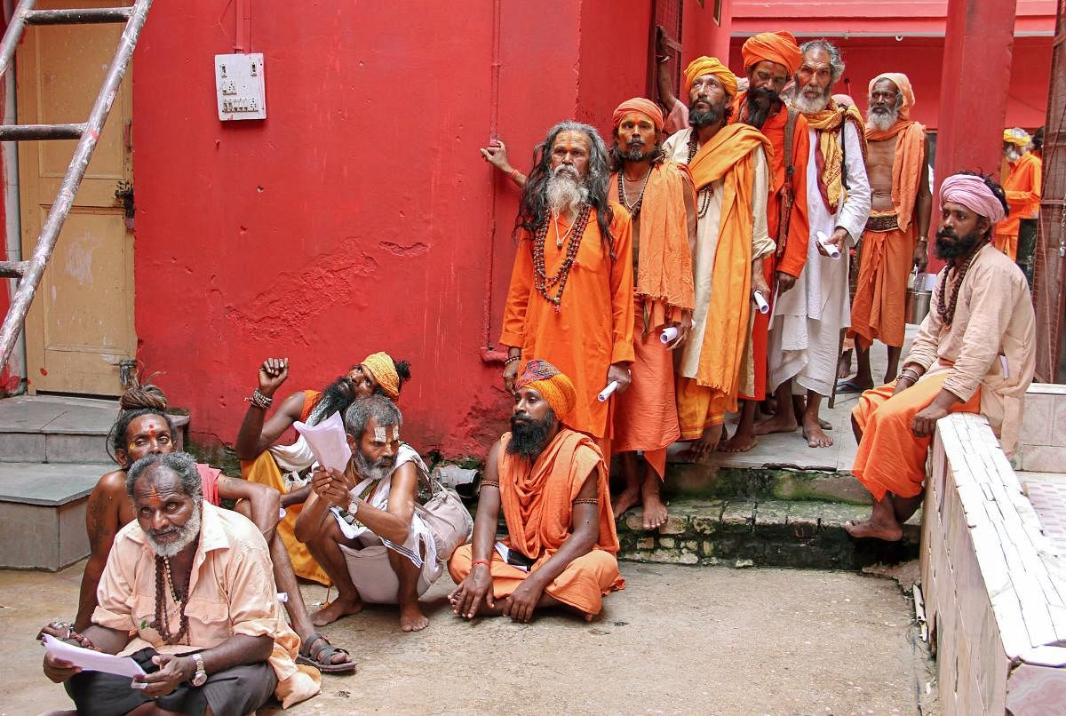 Sadhus wait in a queue for the registration for Amarnath Yatra, which commences on Wednesday, in Jammu on Tuesday. PTI