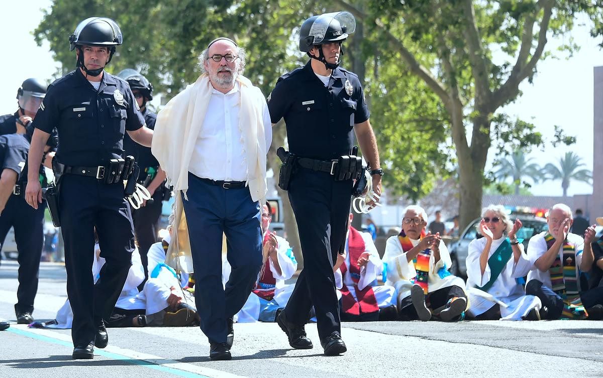 Members of the clergy from different denominations are arrested by police for blocking the road in front of the Federal Building in an act of civil disobedience as they joined activists protesting the visit of Attorney General Jeff Sessions as well as the