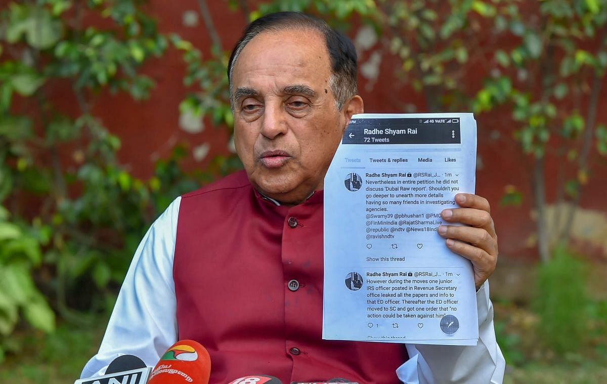 Bharatiya Janata Party MP Subramanian Swamy shows a document while addressing a press conference at his residence, in New Delhi on Wednesday. PTI