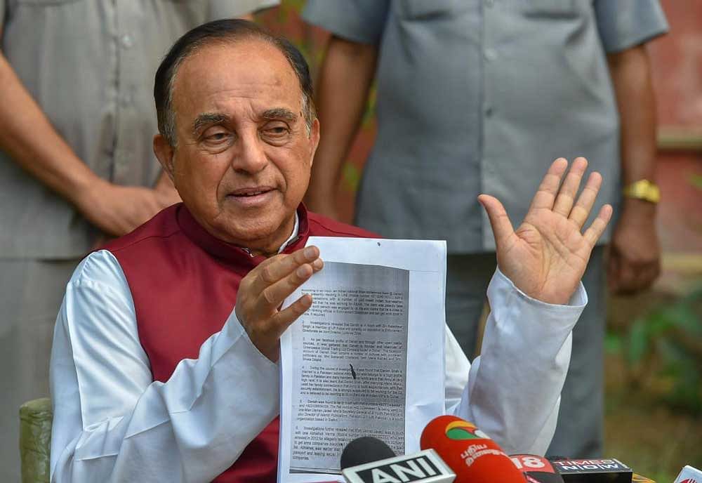 BJP MP Subramanian Swamy shows a document while addressing a press conference at his residence, in New Delhi. PTI Photo